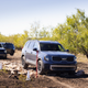 Three blue 2023 Kia Telluride SX X-Pro vehicles drive in a line on a dirt path in San Antonio, TX.